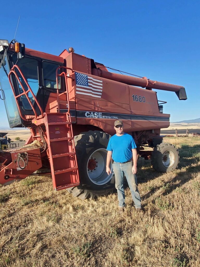 Former Eric Wassmuth standing in front of a combine harvester